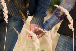 To people holding hands in a wheat field