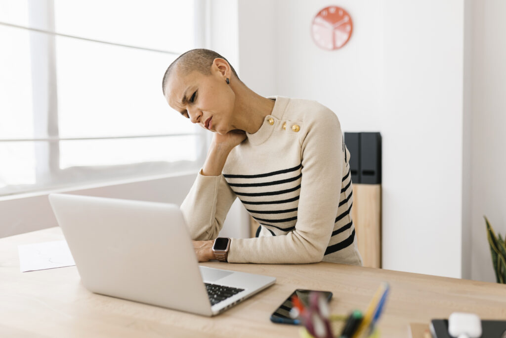 Woman in pain sitting touching her neck